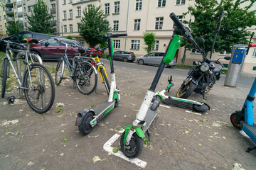 Several bicycles and electric scooters parked together. These modes of transportation are used for active travel on campuses and in cities. E-scooters, rental option in cities. To rent and park.  © Jacek