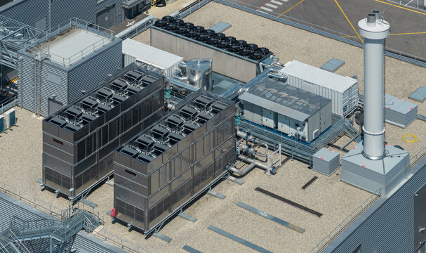 Aerial view of industrial HVAC cooling towers, process piping, and rooftop mechanical equipment at a semiconductor manufacturing facility in Crolles, Auvergne-Rhone-Alpes, France.