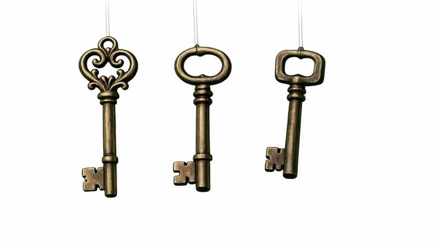 A set of five vintage brass keys with different designs, hanging from hooks against a gray background. The showcases the variety and craftsmanship of old-fashioned locks.