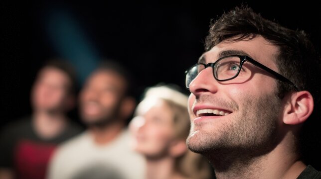 Closeup on a comedic improv actors animated face as they perform a scene with the blackbox studio setting and fellow performers subtly out of focus.