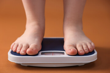 Fototapeta premium Overweight woman on scale against brown background, closeup
