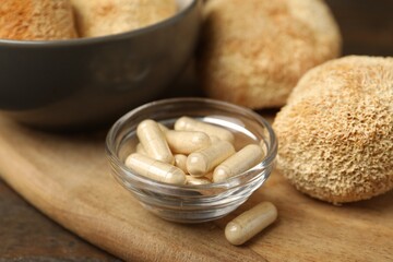 Functional mushrooms and pills on wooden table, closeup © New Africa