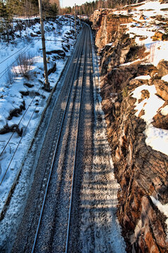 Snowy Railway Tracks Running Through Rocky Cutting in Winter