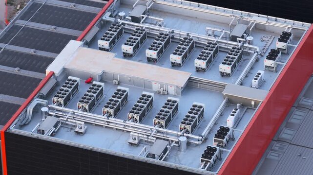 Aerial view of a modern datacenter rooftop featuring multiple industrial HVAC cooling units and ventilation systems in Rome, Lazio, Italy.
