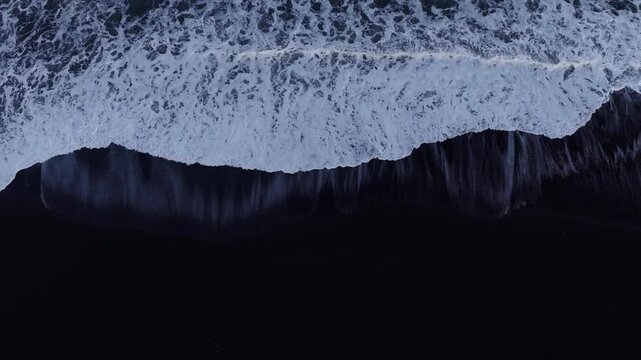 Top Down Drone View of Atlantic Ocean Waves Crashing on Reynisfjara Black Sand Beach, Iceland