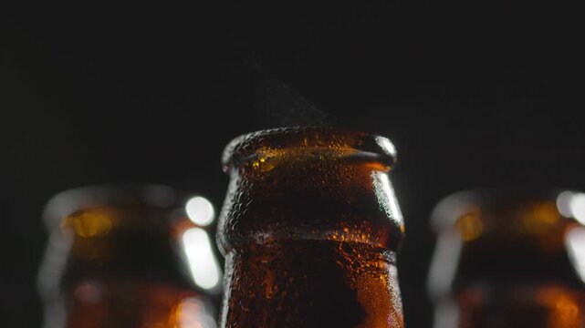 close up beer bottle. Amber glass beer bottle covered with cold water droplets in dramatic light showing refreshing drink condensation chilled beverage texture close up refreshment mood and bar.
