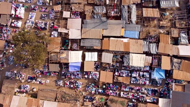 Aerial view of a bustling outdoor market with colorful stalls, tarps, and various goods spread across the ground in Loitokitok, Kajiado County, Kenya.