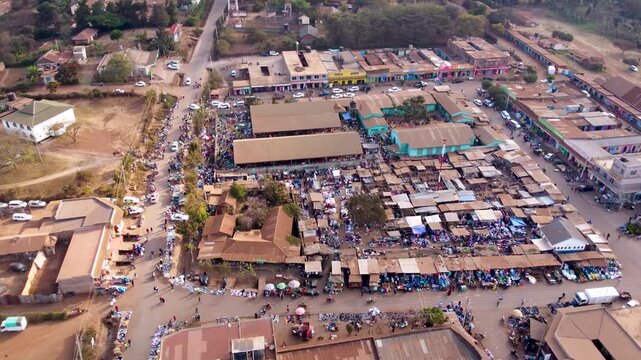 Aerial view of the bustling open-air market with numerous stalls, people walking through the aisles, and surrounding buildings in Loitokitok, Kajiado County, Kenya.