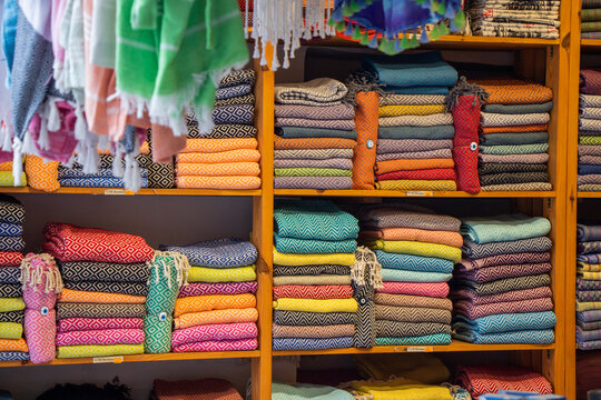 Stacks of multi coloured folded towels for sale on shelves in a shop, Turkey