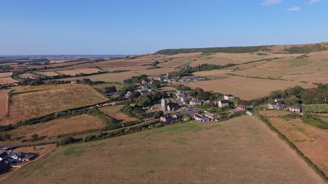 Aerial drone footage of Chale village on the Isle of Wight, England, showcasing the rural village, surrounding countryside, and rolling landscape in warm evening light