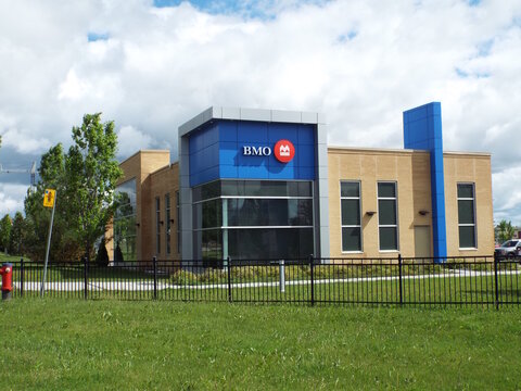 Gatineau, Quebec, Canada &ndash; June 13, 2026: A modern "BMO bank" building with blue and beige architecture sits behind a black fence and a grassy field under clouds at 455 Chem. Vanier.