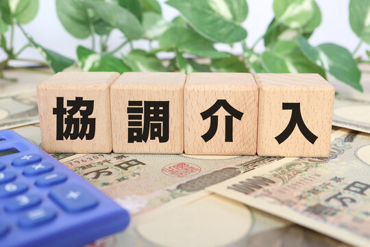為替の協調介入。木製ブロック。電卓と観葉植物。ビジネスイメージ。