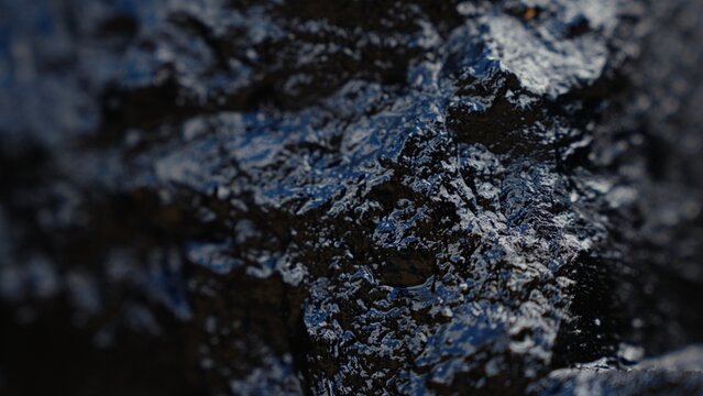 Dark carbon fossil mineral with rough texture forming an abstract background, representing energy, industrial resources, and non renewable fuel
