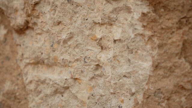 Rough concrete wall showing its aggregate texture, providing a neutral background for construction, architecture, and abstract design concepts