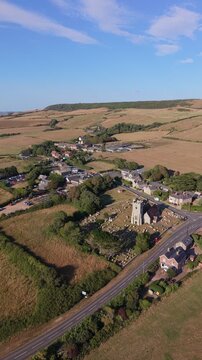 Aerial drone footage of Chale village on the Isle of Wight, England, showcasing the rural village, surrounding countryside, and rolling landscape in warm evening light