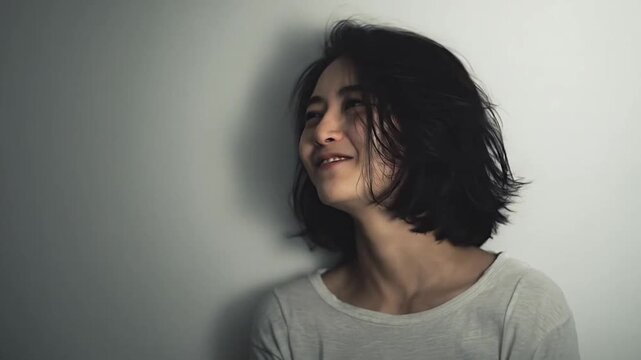 Young woman laughing with genuine joy and closed eyes.