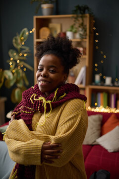 Portrait of smiling young adult African American woman with dwarfism standing in cozy living room, representing body positivity and diversity in lifestyle marketing, vertical