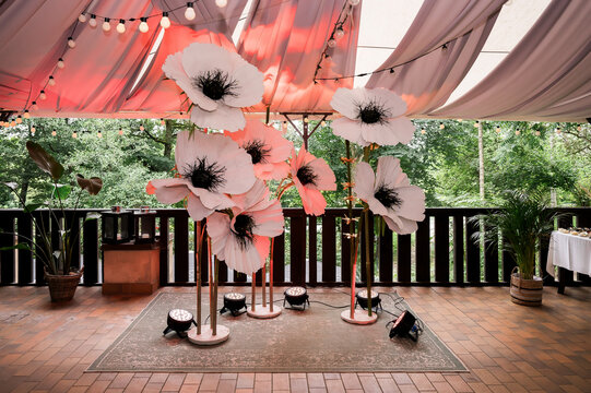 Oversized white floral installation beneath elegant wedding canopy with glowing lights creating luxurious outdoor reception backdrop for modern celebrations and premium event design
