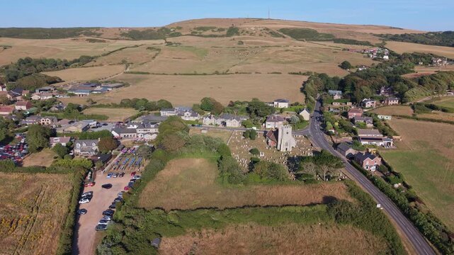 Aerial drone footage of Chale village on the Isle of Wight, England, showcasing the rural village, surrounding countryside, and rolling landscape in warm evening light