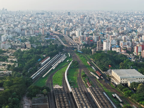 Aerial view of Kamalapur Railway Station featuring its iconic arched roof, multiple railway tracks, and trains, surrounded by the dense urban landscape of Dhaka, Dhaka Division, Bangladesh.