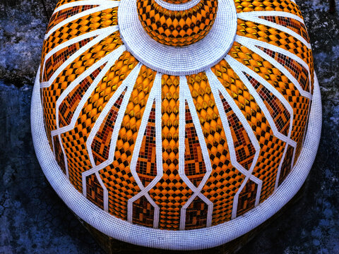 Aerial view of the ornate dome of the 201 Gombuj Masjid featuring intricate yellow and orange mosaic patterns with white geometric lines in Tangail District, Dhaka Division, Bangladesh.