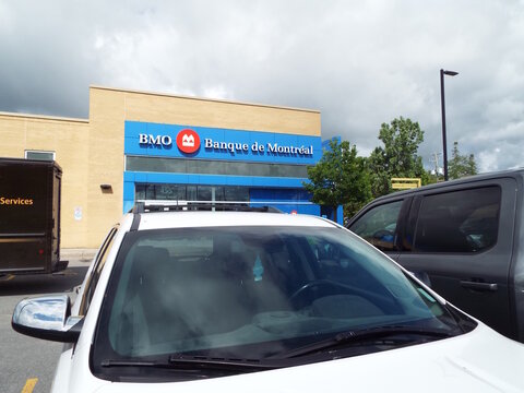 Gatineau, Quebec, Canada &ndash; June 13, 2026: A "BMO" Banque de Montr&eacute;al branch building stands behind parked vehicles under a cloudy sky in an outdoor daytime setting at 455 Chem. Vanier.
