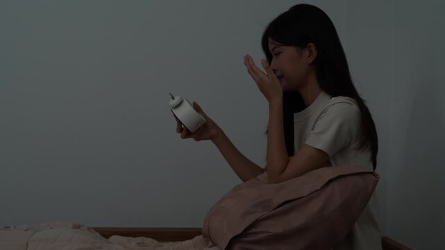 asian woman in bed late trying to sleep suffering insomnia, sleepless or scared in a nightmare, looking sad worried and stressed. Tired and headache or migraine waking up in the middle of the night.