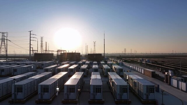 Large-scale energy storage station array landscape during sunrise with industrial modules and power grid infrastructure