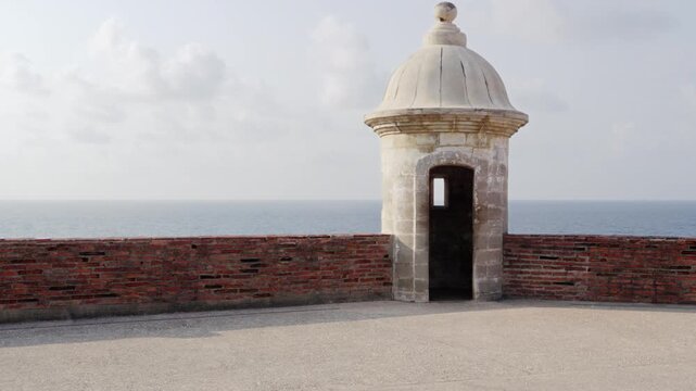 View of a sentry post (Garita), a brick wall, the sea and the clouds at San Cristobal Castle, old San Juan, Puerto Rico