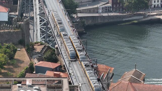 Aerial view of Luis I Bridge with a tram crossing over the Douro River in the historic city center of Porto, Porto District, Portugal.