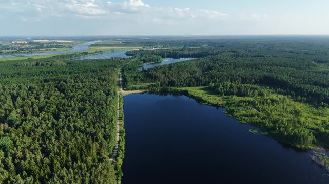 Aerial view of the calm waters of Kalnciems Dolomite Quarry surrounded by dense pine forests in Valgunde Parish, Jelgava Municipality, Latvia.