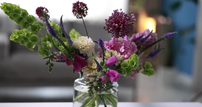 Bouquet of beautiful summer flowers in vase on white table indoors, closeup. Camera moving out