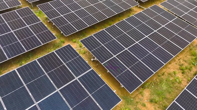 Aerial view of rows of solar panels installed on the ground in a rural area of Tanahgrogot, Kalimantan Timur, Indonesia.