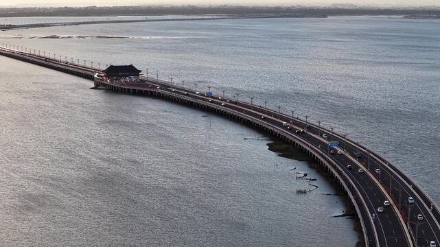 Aerial view of the Bali Mandara Toll Road with its iconic toll plaza stretching across the sea in Kabupaten Badung, Bali, Indonesia.