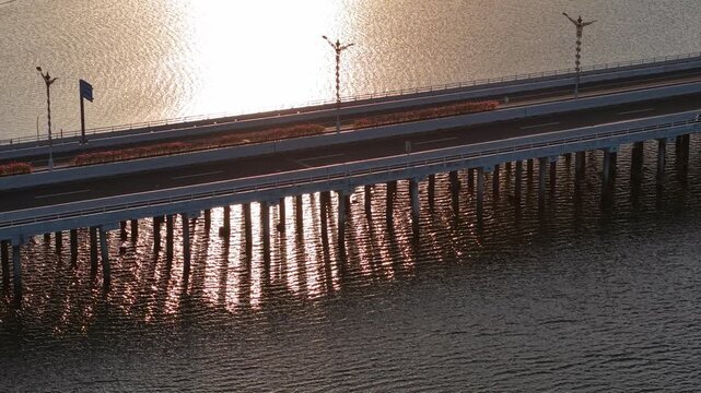 Aerial view of Nusa Dua Toll Plaza over the water at sunset in Kabupaten Badung, Bali, Indonesia.