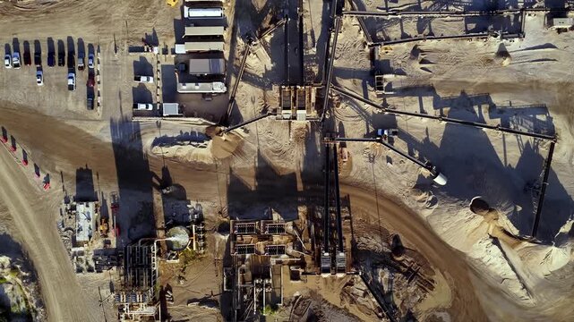 Aerial view of heavy machinery and conveyor systems at a gravel pit and aggregate processing facility in Bluffdale, Utah, United States.