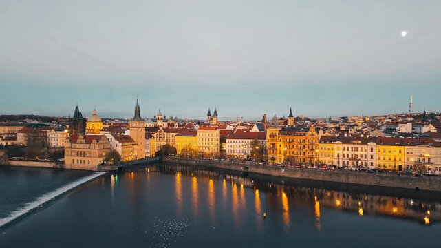 Aerial view of Smetana Embankment along the Vltava River with historic buildings and illuminated windows at dusk in Prague, Hlavni mesto Praha, Czechia.
