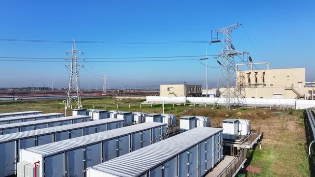 Outdoor energy storage unit array and transmission towers at a substation facility