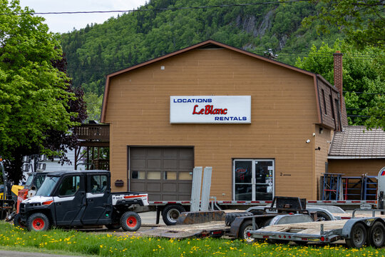 Gaspesie, Quebec, 06 June 2026 : A Bobcat utility vehicle and various trailers are parked outside the LeBlanc Rentals business.
