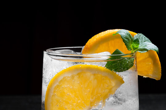 Close Up of Refreshing Citrus Cocktail With Orange Slice Mint and Ice