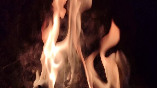 Bright flames burning against a dark background, showcasing intense fire, glowing embers, and dramatic contrast.