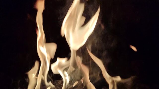 Bright flames burning against a dark background, showcasing intense fire, glowing embers, and dramatic contrast.