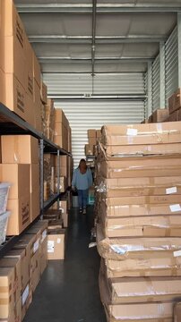 woman carrying a step stool inside of a small warehouse or storage space