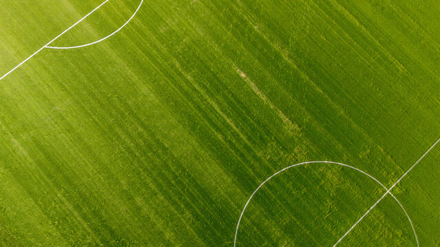 Aerial view of a soccer field with lush green grass and white pitch markings in Gdansk, Poland.