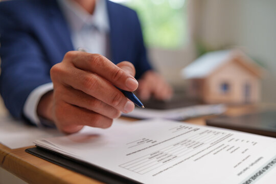 Insurance agent reviewing property documents and financial plans with home ownership protection in focus.