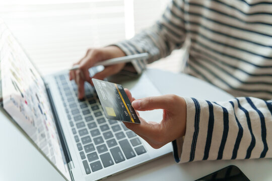 Customer making a secure online purchase with a credit card while using a laptop for digital payment verification and e-commerce checkout.