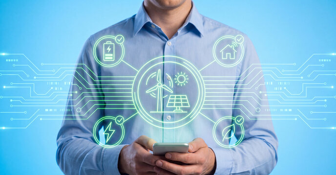 Renewable energy digital interface controlled by professional man holding smartphone showing solar power wind turbine icons on blue background