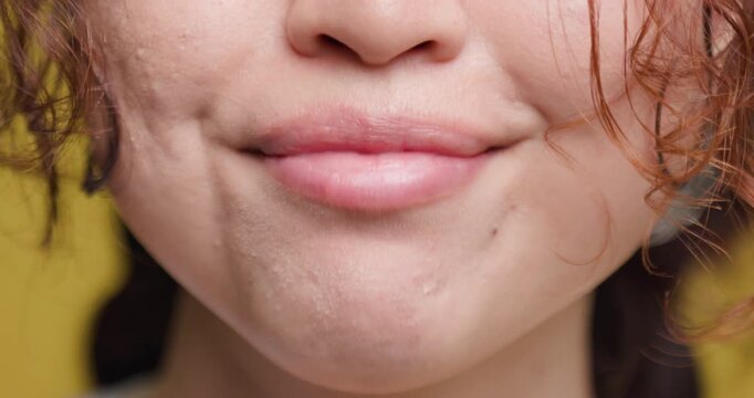 Close-up of a young woman's smiling mouth with natural imperfect teeth