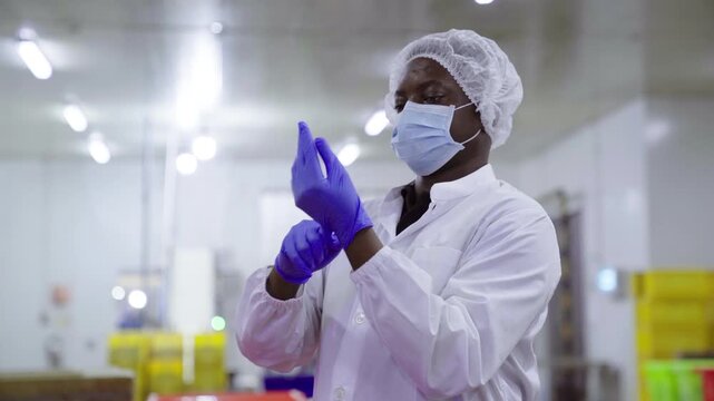 Factory worker getting dressed in protective gear in food plant