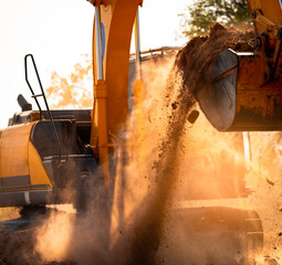 Close-up of excavator at construction site. Backhoe digging soil for earthwork and construction business. Excavating machine at work. Heavy machinery for earth moving and construction site development © Fahroni